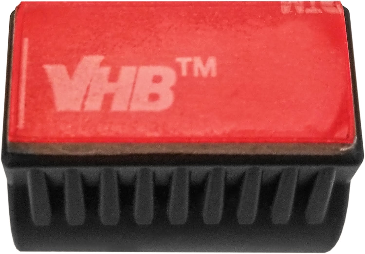 The Nightstick XPP-5411GX Intrinsically Safe Penlight w/Mount features a black rectangular plastic mount with ridged sides and a red "VHB™" adhesive strip, ideal for securely attaching an IP-67 waterproof flashlight.