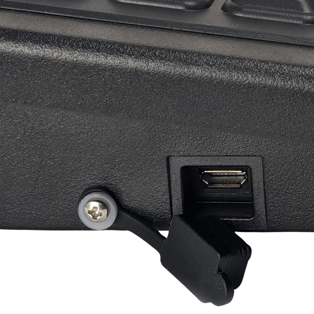 Close-up of the Armadex BT-Key-02 ATEX Intrinsically Safe Keyboard with a black device, Mini USB port, open protective flap, and secured hinge; perfect for ATEX Zone 2 and IECEx certified use.