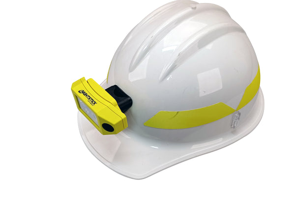 A white hard hat mount helmet with yellow reflective strips, featuring a Nightstick XPP-5460GCX Zone 0 IS Low-Profile Dual-Light Headlamp w/kit attached to the front.