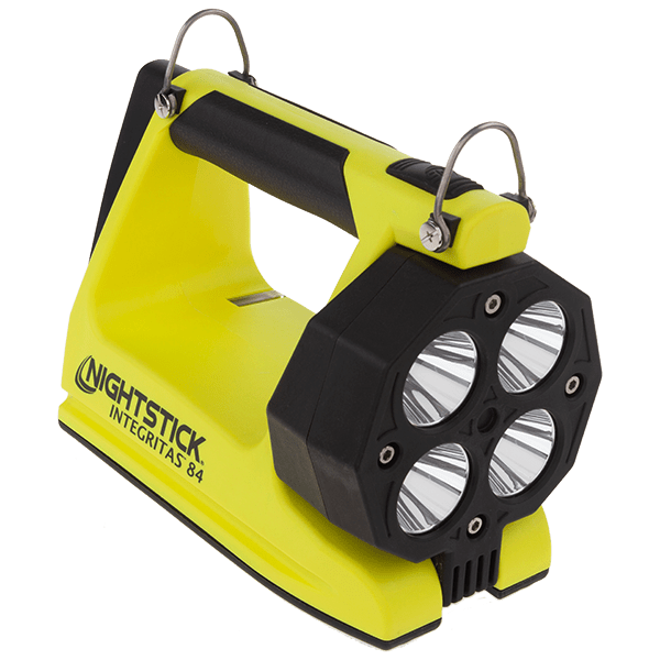 A yellow and black Nightstick XPR-5584GMX INTEGRITAS™ intrinsically safe rechargeable lantern with a handle, four advanced LED bulbs, two metal hooks on top, and a magnetic base.