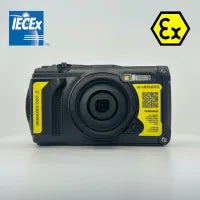 A rugged black camera with yellow labels is shown. The IECEx and Ex safety certification logos are visible, indicating it is designed for use in hazardous environments.