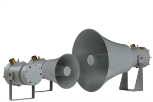 Two E2S D1xL1F 117dB(A) 15W explosion proof speakers with marine grade aluminium enclosures, in different sizes and industrial gray finish, are mounted on metal stands against a plain white background.