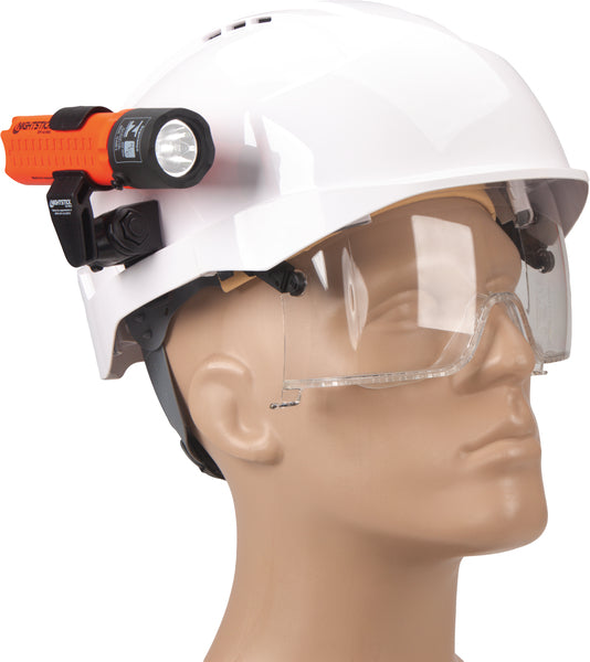 A mannequin head wears a white hard hat with a Nightstick XPP-5418RX-K01 Zone 0 IS Flashlight mounted on the side and clear safety glasses, demonstrating NFPA-1971-8.6 compliant safety gear.