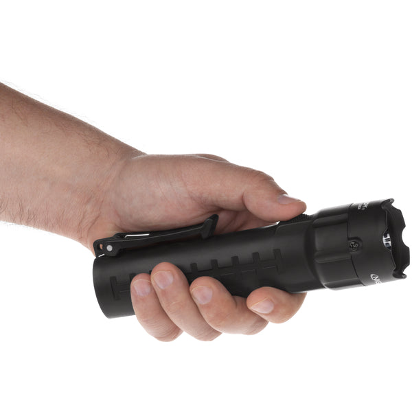 A person holds a Nightstick XPP-5420BA [Zone 0] IS Torch, a black ATEX flashlight with a clip, against a white background.