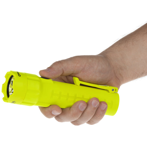 A hand holds the Nightstick XPP-5420GA [Zone 0] IS Torch, a bright yellow, intrinsically safe LED flashlight with a clip, shown horizontally against a white background.
