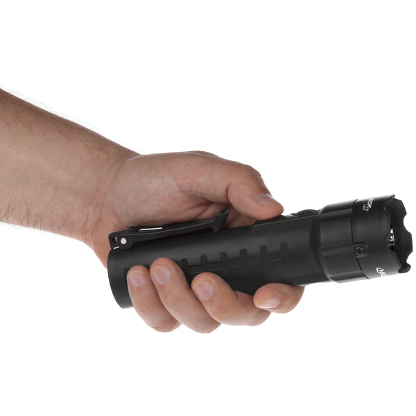 A hand holds the Nightstick XPP-5422B [UL-913] IS Permissible Dual-Light Flashlight with a clip, against a plain white background.