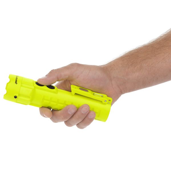 A person holds a bright yellow Nightstick XPP-5422GMA [Zone 0] IS Dual-Light Flashlight with dual magnets and a clip, shown against a white background.