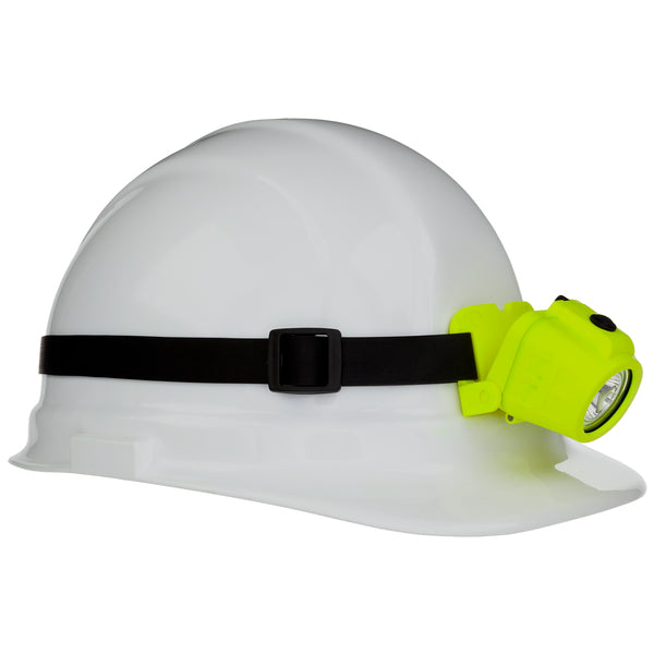 A white hard hat with a black strap features a Nightstick XPP-5450G [Zone 0] IS Dual-Function Headlamp, a bright yellow Intrinsically Safe LED spotlight, attached to the front left side.