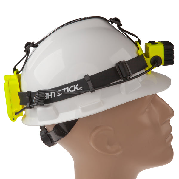 A mannequin head in profile facing right wears a white hard hat featuring a yellow Nightstick XPP-5456G [Zone 0] IS Permissible Dual-Light Headlamp and battery pack.